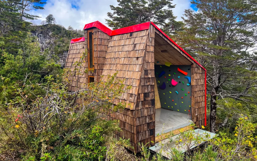 Toma de una estructura con techo rojo y ventanas que es uno de los proyectos medioambientales de Los 16.