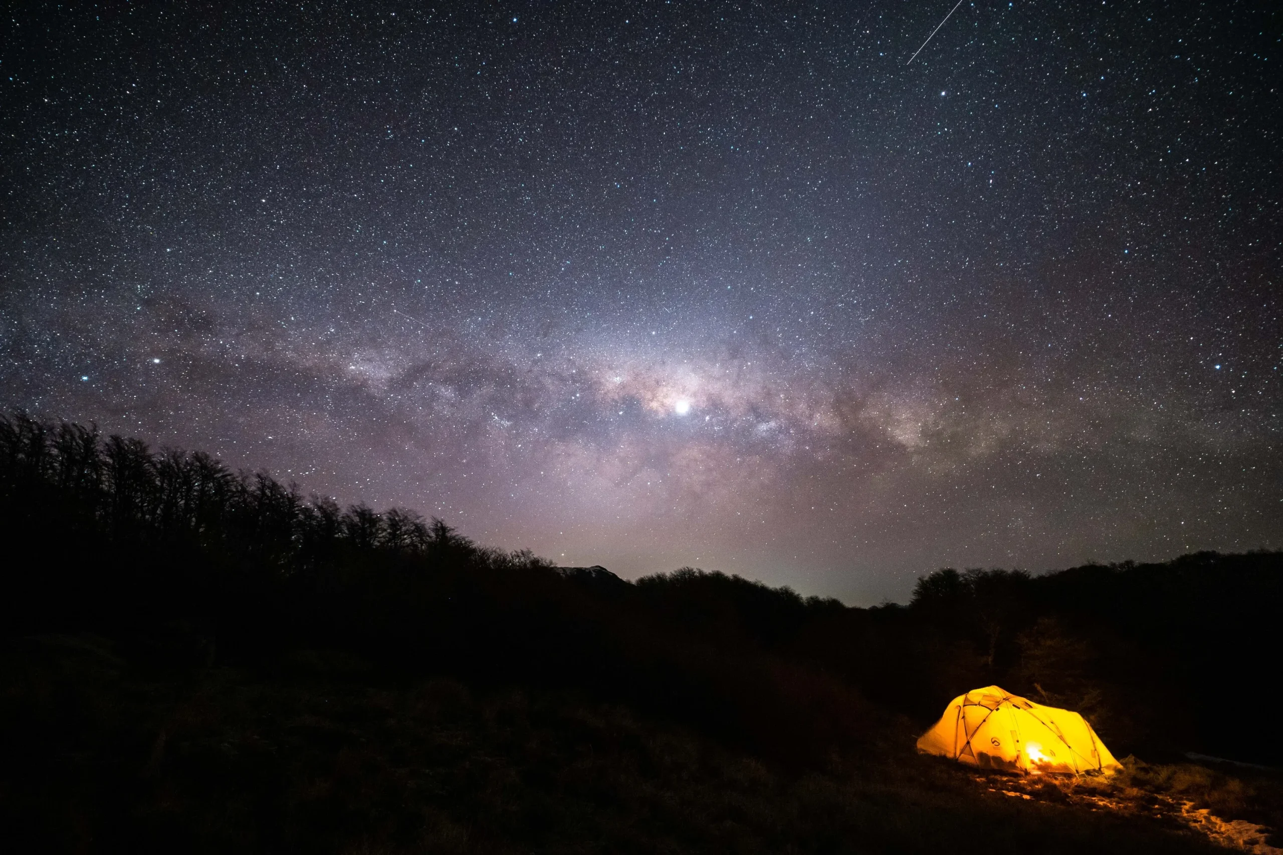 Fotografía de una casa para acampar con luz encendida durante la noche al aire libre cerca del volcán Ojos del Salado.