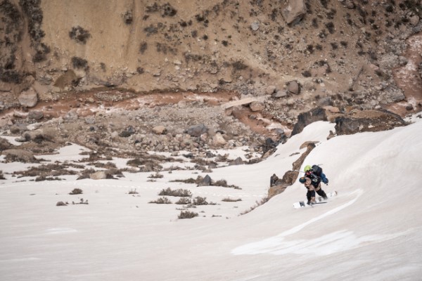 Fotografía de un hombre con chamarra y gorro caminando por una de las rutas de trekking Chile cubierta de nieve.