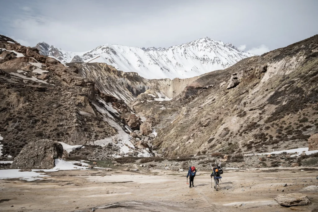 Fotografía del montañista chileno Juan Pablo Mohr en compañía de otro alpinista caminando sobre una zona cubierta de nieve.