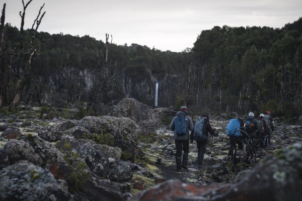 Fotografía de 4 personas caminando en grupo en una de las rutas de trekking Chile usando chamarras y gorros.