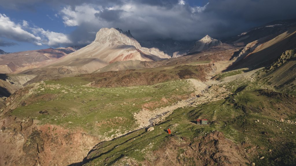 Fotografía de zona montañosa con áreas verdes donde hay refugios de montaña en las distintas regiones de Chile.